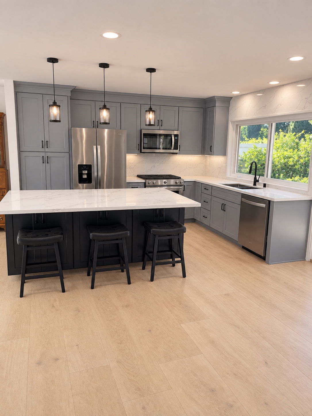 Light grey Shaker kitchen with a dark island, three stools and black pendant lights